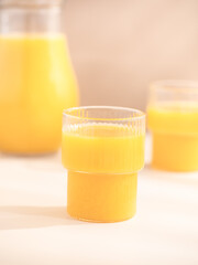 Orange juice in glasses on a light background.