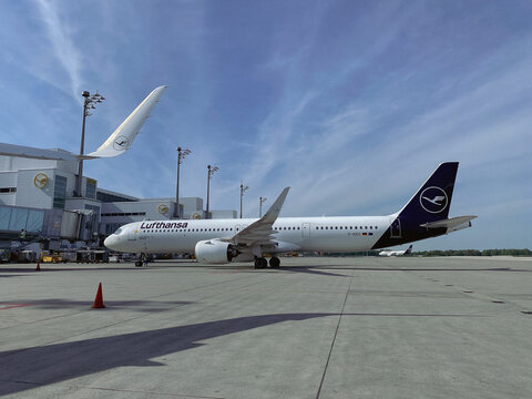 Lufthansa Airbus A321 Neo at gate of Munich Airport Terminal 2 with apron and blue sky taken on 9 May 2023