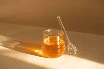 Honey in a glass transparent jar. 