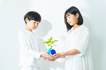 地球の描かれた植木鉢を持つ子供たち　環境保護イメージ