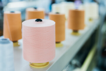 Close-up view of pink sewing thread Close to other threads are placed on the machine. in the weaving industry to wait for the production of designed clothes