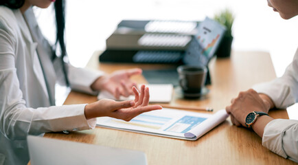 Two young business people working together, discussing and consulting business strategy.