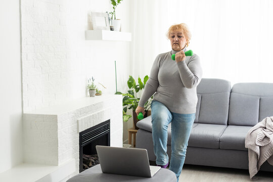 Home Sport. Active Senior Woman Doing Warming Stretching Exercises In Front Of Laptop, Training With Online Tutorials