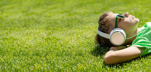 A boy relaxing on grass, listening to music