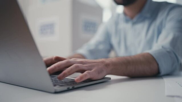 Close-up hands of male poll clerk typing on laptop, verifying voters data