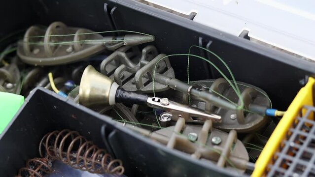 Lots of metal feeders for feeder carp fishing. Fishing tackle box, fully stocked with fishing tackle. clipping path. Flat feeder. Fishing troughs and bait for fish. A set of feeders for fish.