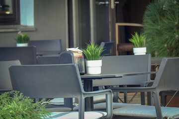 Gray metal tables and chairs outdoor cafe design with plants