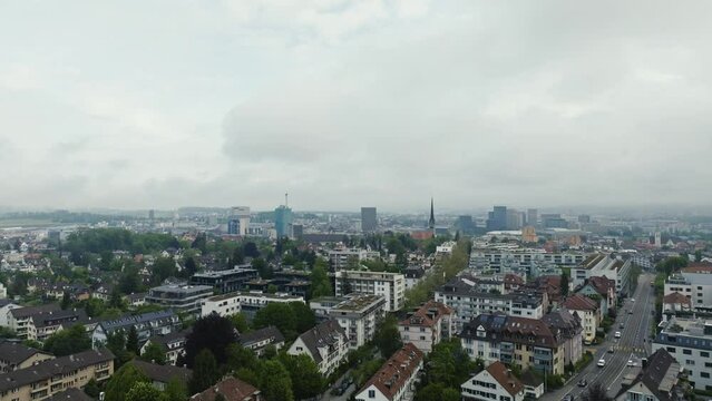 Aerial view of City of Z&uuml;rich with skyline and skyscrapers and rural road on a cloudy spring morning. Movie shot May 9th, 2023, Zurich, Switzerland.