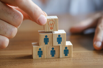 Man holding a wooden cube with light bulb on it. Teamwork and employment business concept