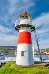 Torshavn, Faroe Islands - Lighthouse, old military fortress Skansin with cannons, WWII guns and tourists in the modern capital Torshavn of Faroe islands