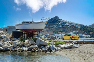Repairing sail boat and a yellow car in the harbor of Skyros island, Greece