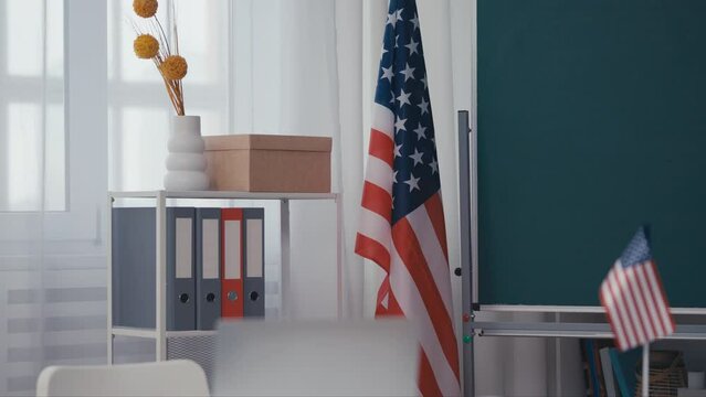 American government agency office with USA flag, folders on shelf, workplace