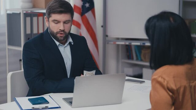 Corrupt US official receiving bribe in envelope, selling passport illegally