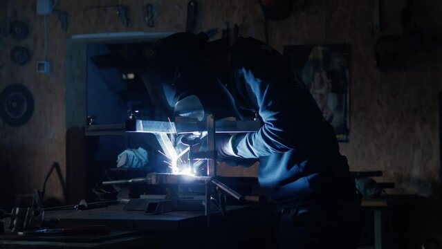 This stock footage clip captures a masterful welder in action, creating sparks as they expertly join pieces of metal together using their welding torch.