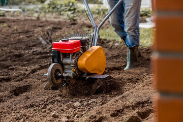 Banner. Man Farmer plows the land with a cultivator. Agricultural machinery: cultivator for tillage...