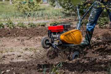 Banner. Man Farmer plows the land with a cultivator. Agricultural machinery: cultivator for tillage...