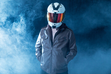 male motorcyclist wearing helmet standing in smoke