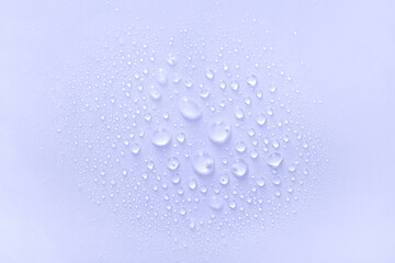 water drops of transparent gel serum on a pastel purple background