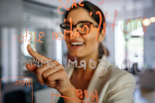 Woman Working And Writing On The Glass Board In Office. Business, Technology, Research Concept