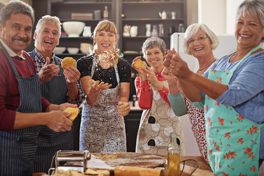 Portrait, happy senior people having fun kitchen and at cooking class. Achievement or success, baking or cooking collaboration and teamwork of elderly group cheering or celebrating together