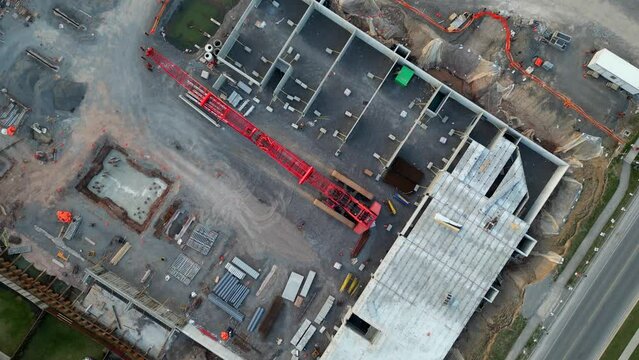 Top down aerial of large crawler crane lifted at construction site after hours