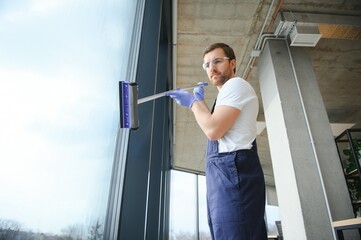Male worker washing window glass