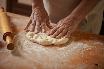Women's hands make pasty dough