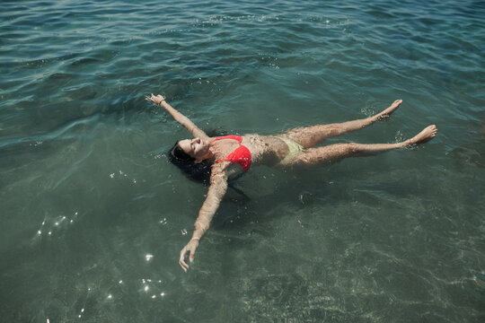Woman in bikini floating on the sea water