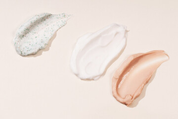 Cosmetic smears of creamy texture on a pastel beige background. Cosmetic background cream care product.