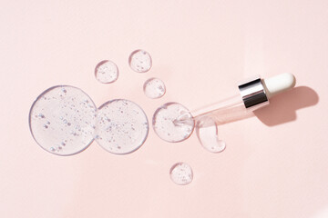 Drops and smears of cosmetics. Drops of liquid transparent gel with bubbles on a beige background.