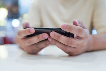Man playing game on mobile phone. gamer boy playing video games holding Smartphone working mobile devices. cell telephone technology e-commerce concept