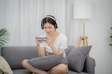 Asian woman playing game on mobile phone. gamer girl playing video games holding Smartphone working mobile devices. cell telephone technology e-commerce concept