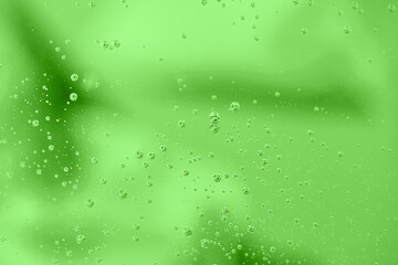Water drops on green background. Abstract water bubbles on glass over green.