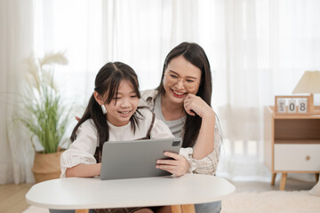 Asian family smiling of mother and daughter using the tablet in the home