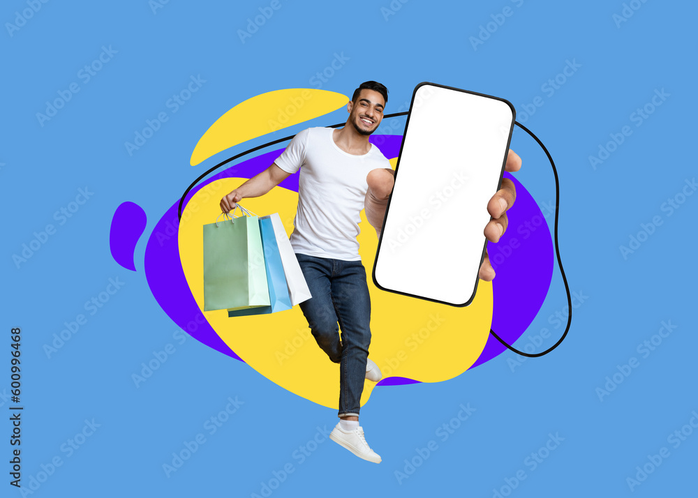 Wall mural Shopping App. Happy Arab Man Jumping With Shopper Bags And Blank Smartphone