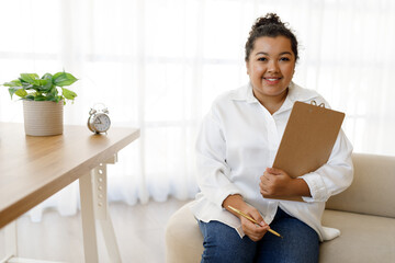 Happy young mixed race lady psychologist posing at clinic
