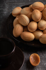 photo dessert nuts with condensed milk on a plate and coffee on the table