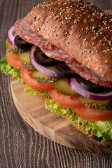 photo sausage and vegetable sandwich on a wooden board