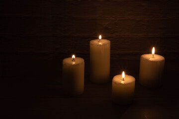 Obraz na płótnie Canvas photo four burning candles of different sizes
