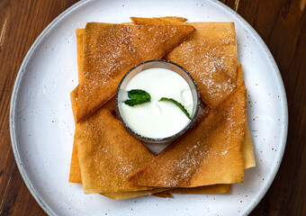 Crispy homemade Banana pancake with dipping serving on round white plate, Food Desert concept