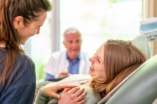 LGBT couple visiting medical center for ivf and pregnancy control, smiles and happiness emotions from their looks
