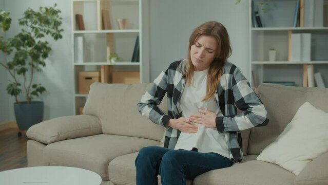 Woman With Stomach Ache. Woman Feeling Abdominal, Ulcer in her Tummy, or Menstrual Pain at Home. Gastritis, Diarrhea, Pancreatitis and Painful Periods Concept.