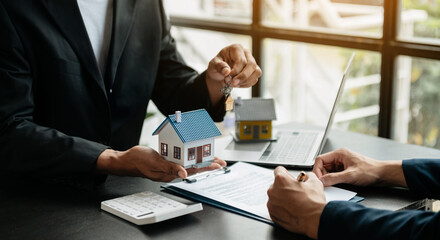 Real estate broker agent presenting and consult to customer to decision making sign insurance form agreement, home model, concerning mortgage loan offer