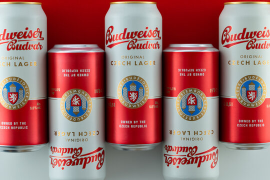 Aluminium cold Budweiser Budvar lager beers on the red and white background.