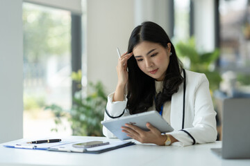 Confident businesswoman, corporate employee working online on tablet E-learning about business in finance, insurance, income, tax at the office management concept.