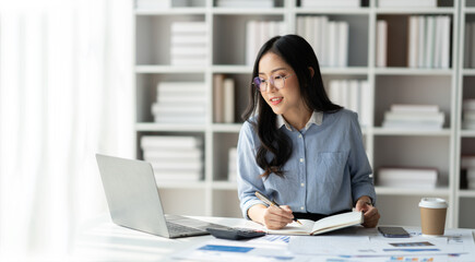 copy space, panorama, banner Modern working lifestyle Asian businesswoman sits at desk with laptop online using internet and notepad happily recording receipt contact information online delivery.