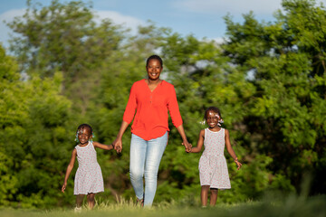 Naklejka na ściany i meble Two black-skinned sisters sunset with their mom