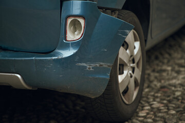 Closeup of a damaged car. Rear bumper dent. Concept of road traffic accident reduction campaign