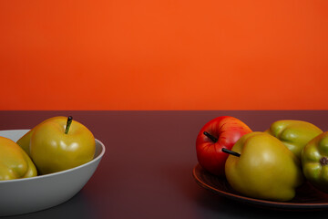 A plate with apples on the table. Orange background. Fruits.