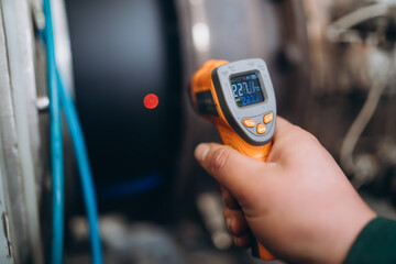 An engineer uses a thermal imager to check the heating temperature of a pvc pipe.